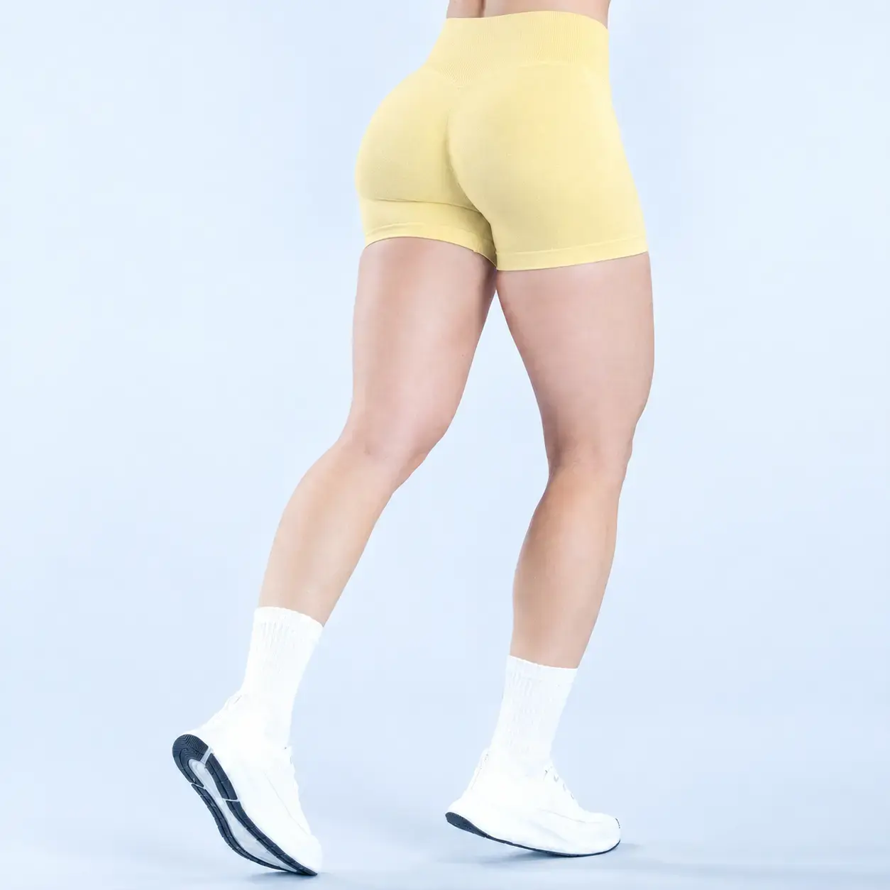 Short Nébula amarillo de tiro alto sin costuras, vista de espalda con fruncido que levanta la cola